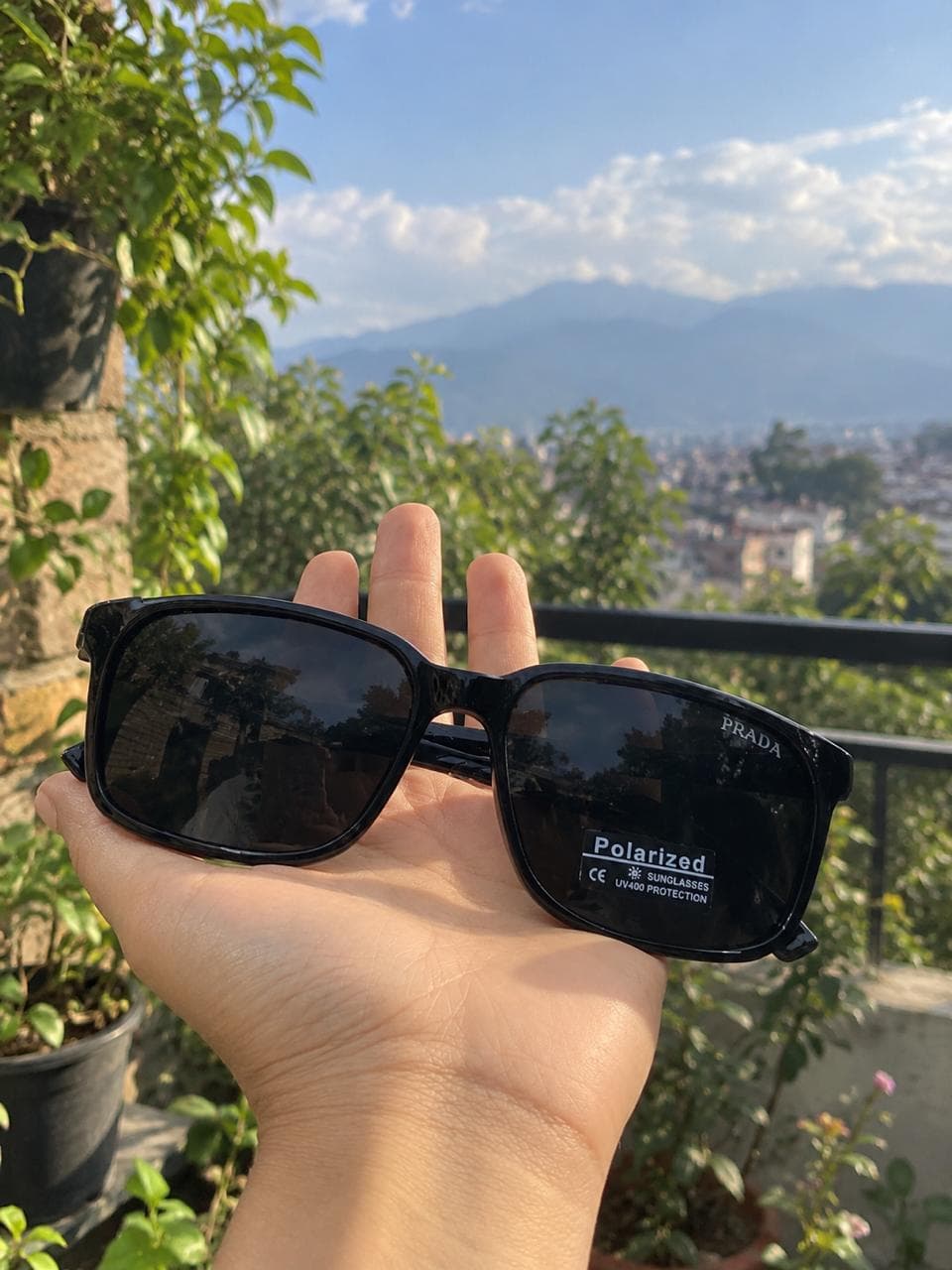 Glossy black sunglasses displayed on a gold stand
